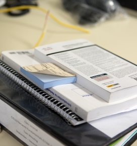 A stack of books sits on a desk