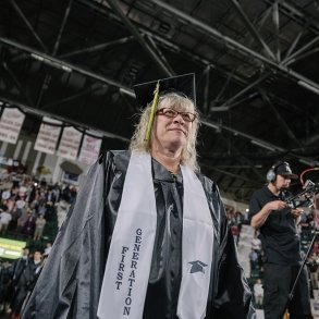 A graduate walks in to Commencement 2024