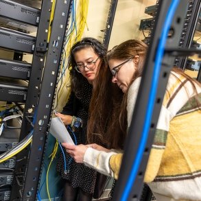 Two women look over an assignment in the IT room at SUNY Adirondack
