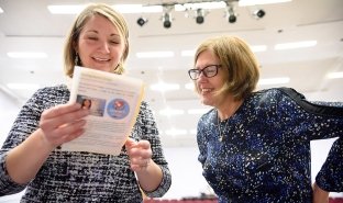 Mary McDermott looks over a program at a Nursing pinning ceremony.