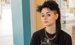 Amber Rzeszuto wears a Smashing Pumpkins T-shirt, has black, spiky hair and is looking directly at the camera