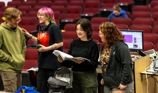 Mary Pilot, second from right, reviews notes for an upcoming production of "The Addams Family"