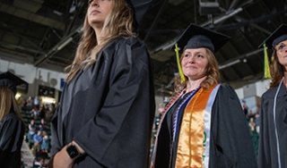 Graduates walk into the 2023 Commencement ceremony at Cool Insuring Arena.