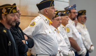 Veterans are seen standing at attention in a Veterans Day ceremony at SUNY Adirondack in 2024.