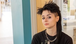 Amber Rzeszuto wears a Smashing Pumpkins T-shirt, has black, spiky hair and is looking directly at the camera