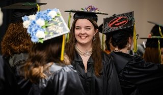 Graduates smile as they prepare to line up for commencement ceremony in 2025.