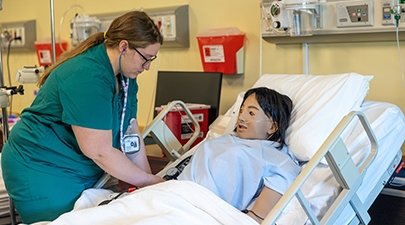 A nursing student works in the simulation lab