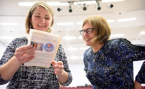 Mary McDermott looks over a program at a Nursing pinning ceremony.
