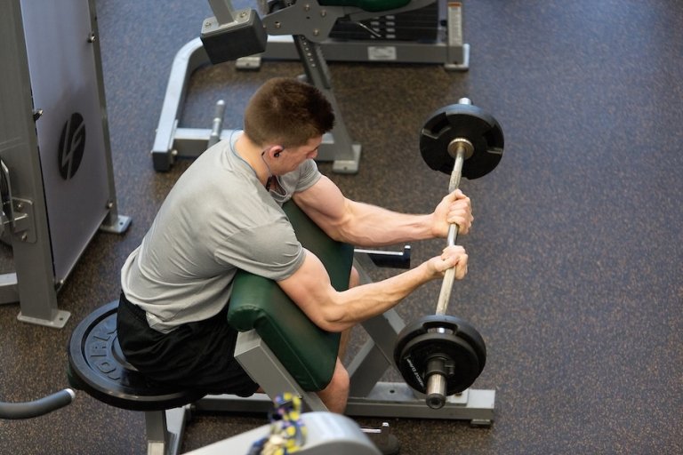 A student lifts weights in the Fitness Center